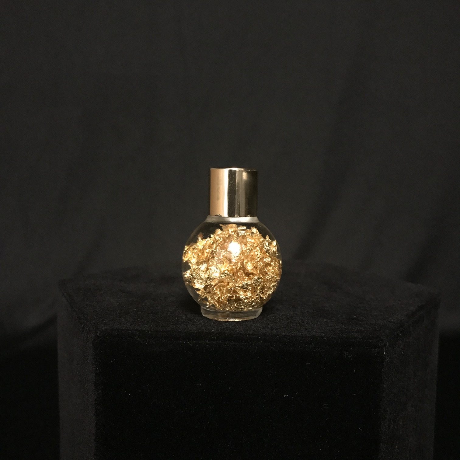 Captivating bottle of gold flakes, suspended in liquid, available at natur.